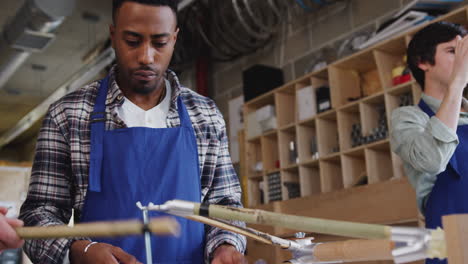 Multi-Cultural-Team-Of-Trainees-In-Workshop-Learn-How-To-Assemble-Hand-Built-Bamboo-Bicycle-Frame