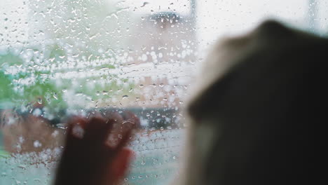 girl silhouette leaning on window while woman cleans glass