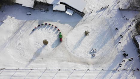 christmas themed tractor pulling sleighs full of kids