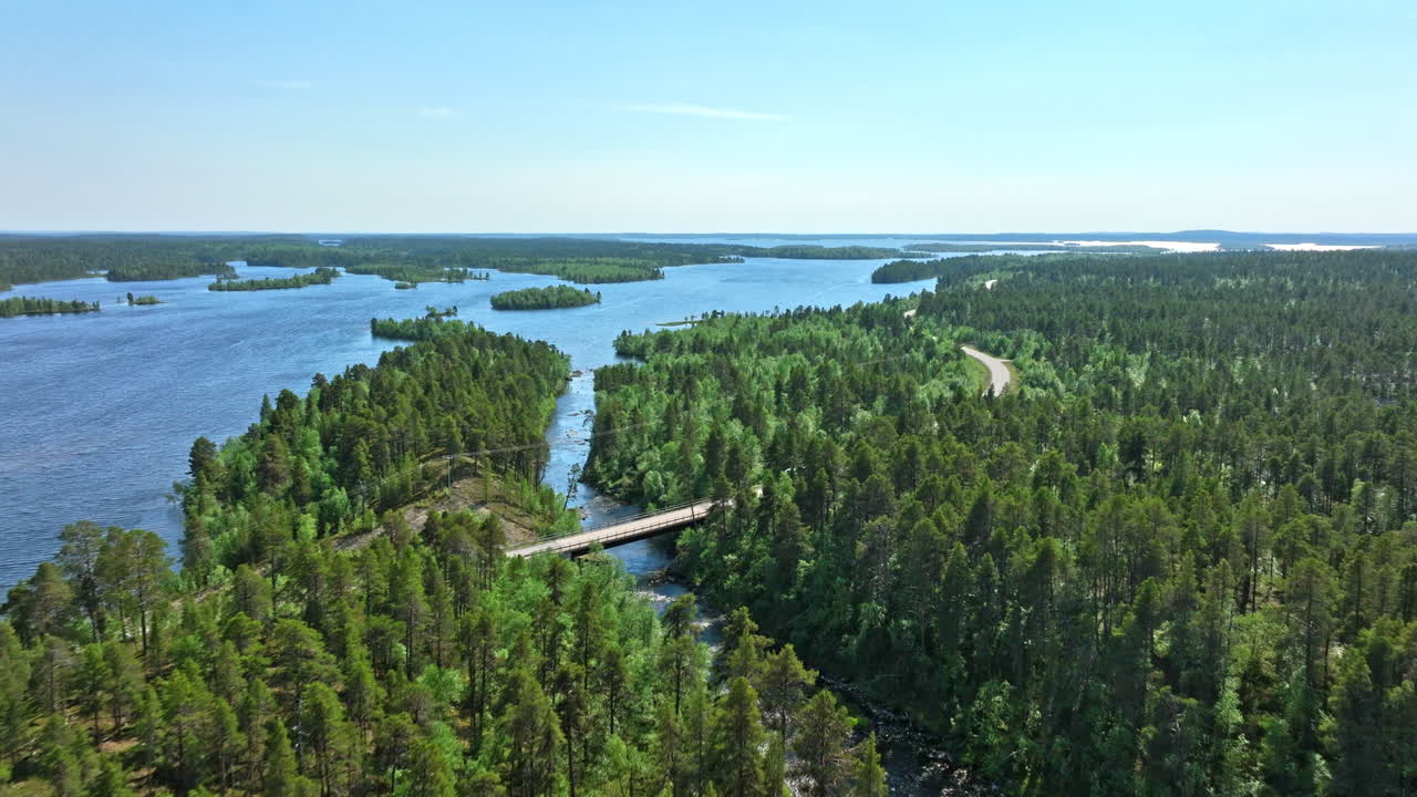 AERIAL: Camper van driving in middle of polar lakelands of Lapland, summertime