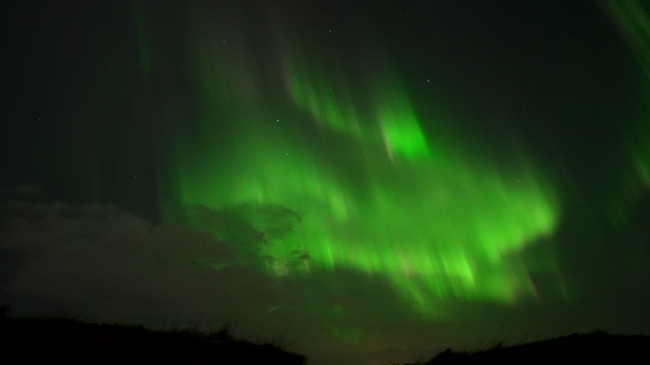 estallando aurora boreal en el oscuro cielo nocturno. mano