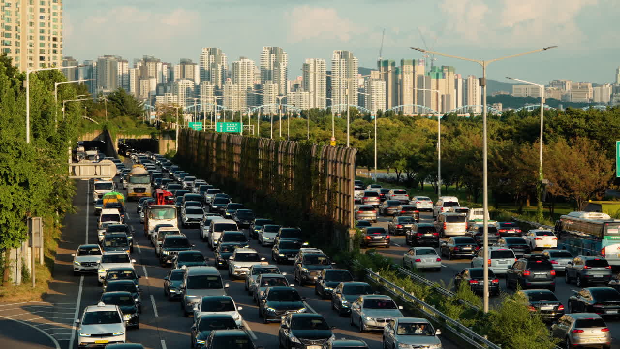 tráfico masivo de automóviles de seúl en la autopista gangbyeonbuk-ro durante la puesta del sol, innumerables automóviles conducen lentamente de parachoques a parachoques en una amplia autopista de varios carriles en ambos sentidos - vista de alto ángulo