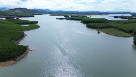 drone descending above forested islands in a quiet lake surrounded by hills