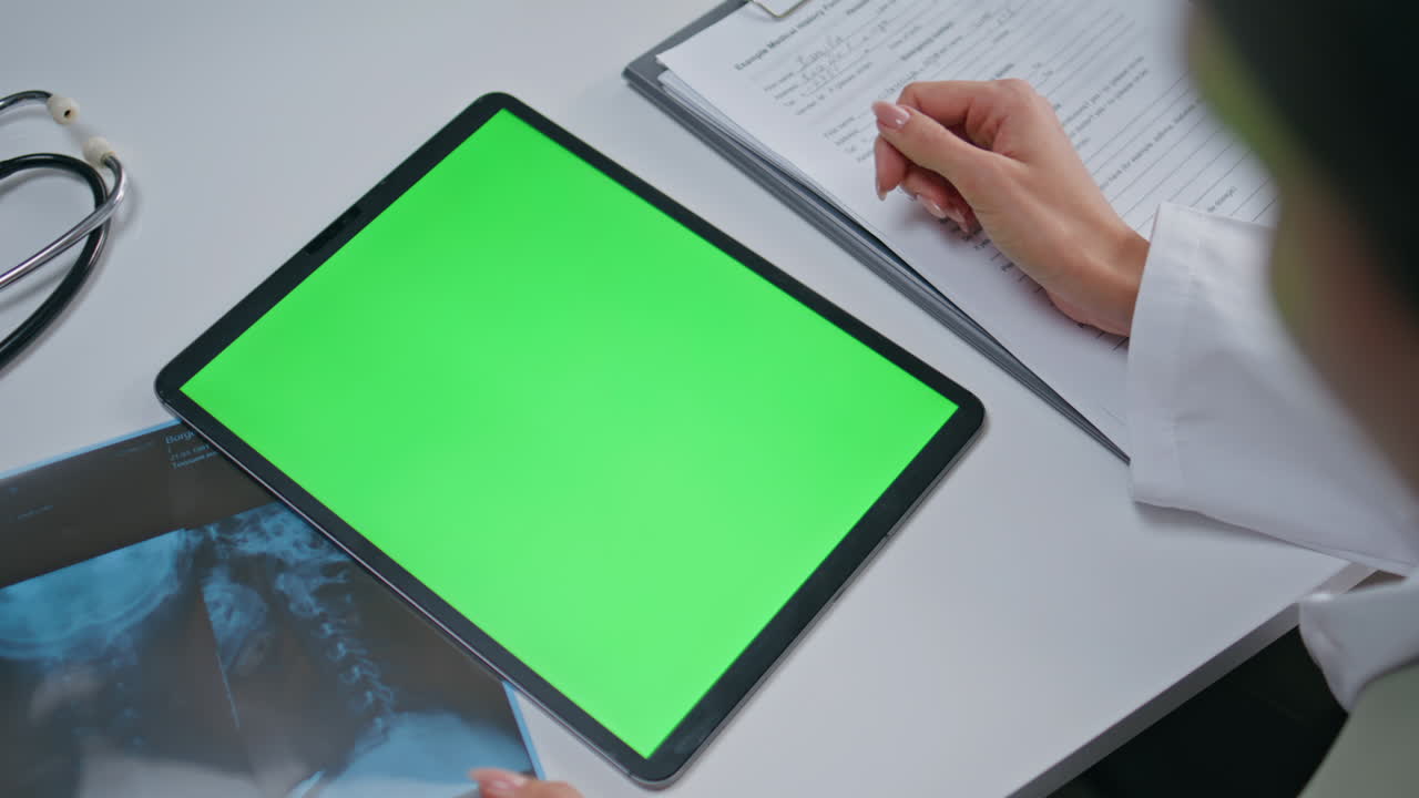 Physician using green screen tablet at clinic healthcare consultation closeup