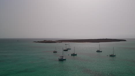 aerial view of many luxury yachts moored in the bay of sal rei city, background the island of djeu , boa vista, cabo verde