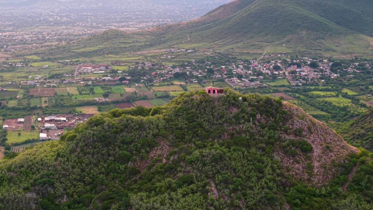 Prospettiva drone del Cerro Danush coronato da una cappella colorata in cima a una collina. Oaxaca, Messico
