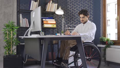 Un-Trabajador-Discapacitado-Sentado-En-Silla-De-Ruedas-Trabajando-En-La-Computadora.