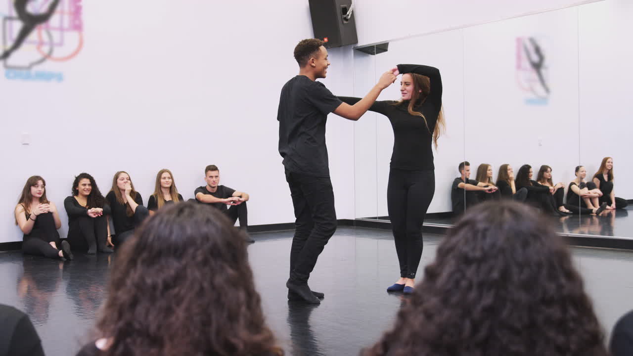 dos estudiantes de danza en la escuela de artes escénicas realizan danza para la clase en el estudio