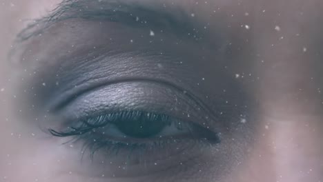 animation of snow faling and purple shapes over eye of biracial woman