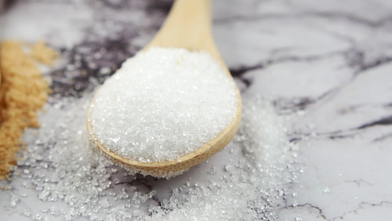 azúcar blanco y marrón en cucharas de madera