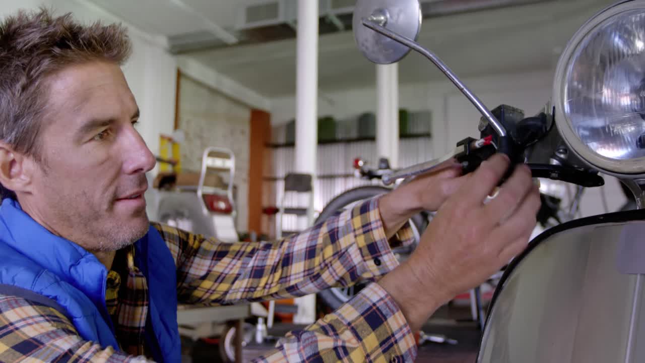 Male mechanic repairing scooter in repair garage 4k