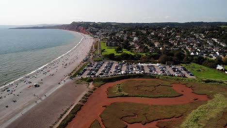 Antena-Sobre-El-Estuario-De-La-Nutria-Con-Vista-Al-Estacionamiento-Del-Horno-De-Cal-Y-Al-Pueblo-De-Budleigh-Salterton-En-El-Fondo