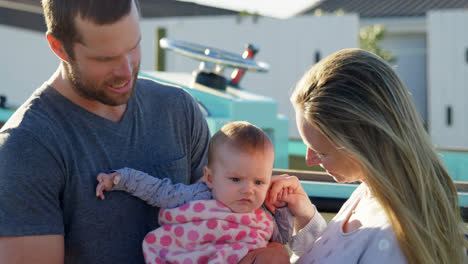 Parents-holding-baby-boy-at-backyard-4k