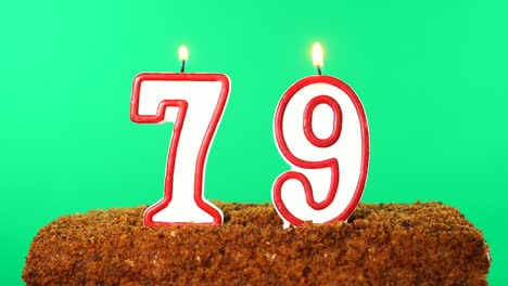 cake with the number 79 lighted candle. chroma key. green screen. isolated