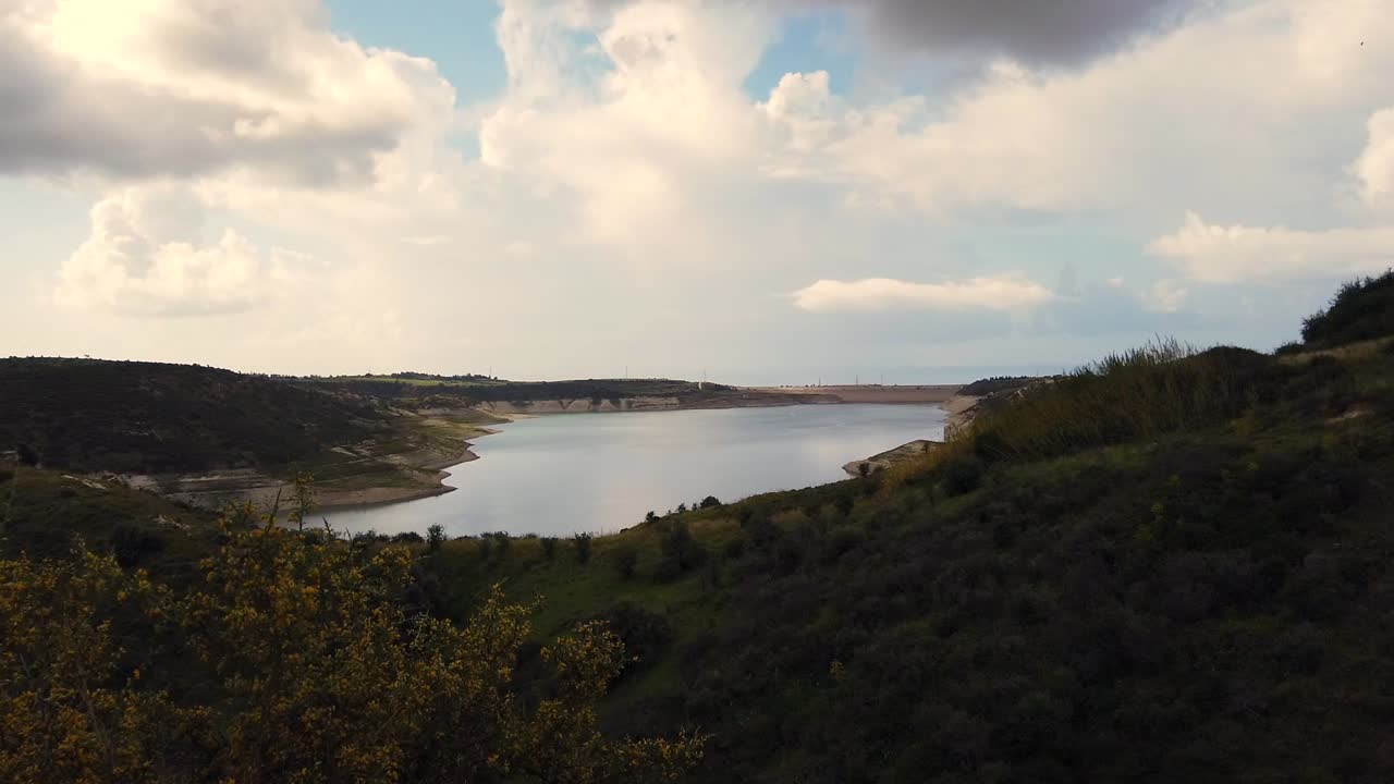 Closer view of Paphos Dam in Cyprus, showing calm water and full dam structure from the edge. A detailed look at the reservoir, ideal for environmental, travel, or infrastructure footage.