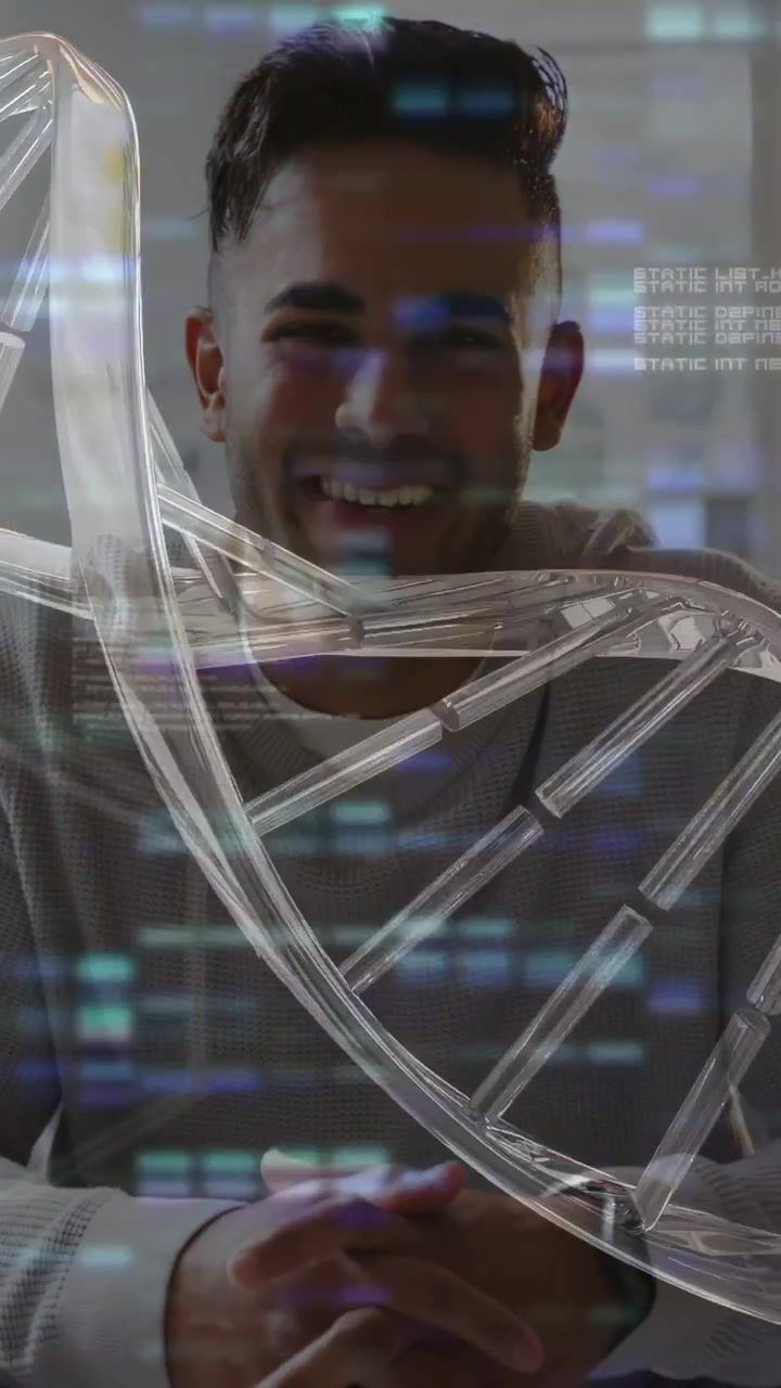 Vertical video: Man sitting at table reacting to DNA helix appearing, smiling during tech demo