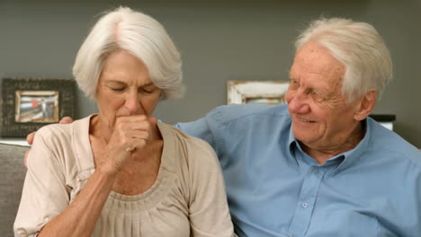 old woman coughing next to her husband