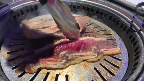 한식당에서 뜨거운 스테인리스 스틸 그릴에서 한국식 바비큐 요리하기