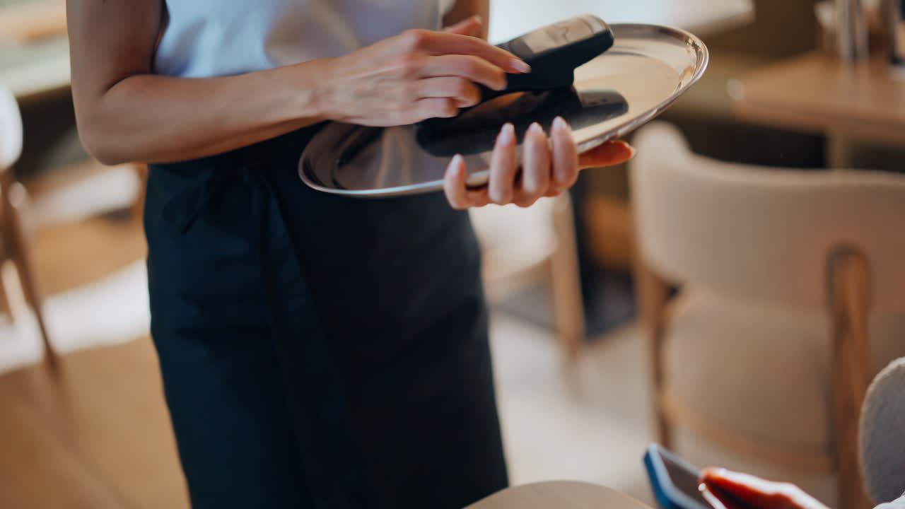 Unknown waitress bringing terminal to client closeup. Businesswoman paying bill