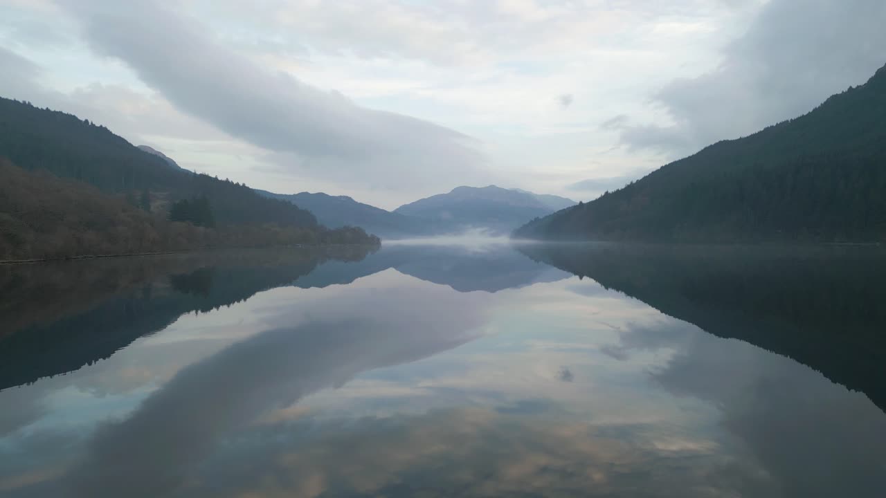 Right-to-Left Aerial View of Misty Water Reflections and Mountain Scenery