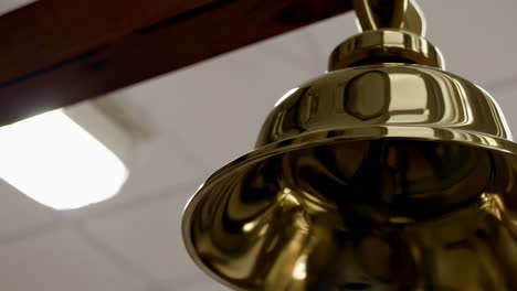 golden bell hanging from wooden frame