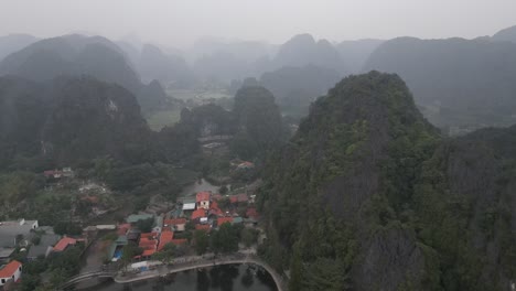 drone-shot-of-small-village-amongst-mountains-in-the-mountainous-region-of-Ninh-Ninh-in-Northern-Vietnam