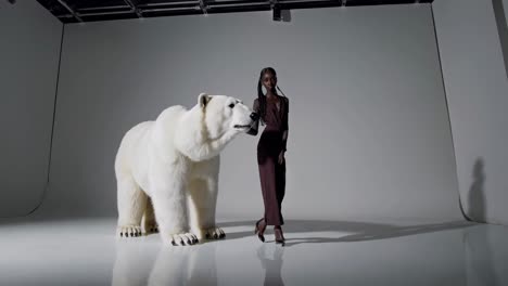mujer posando con un oso polar en el estudio