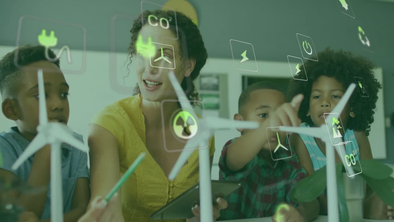 animación de iconos de energía sobre feliz maestra diversa y alumnos con turbinas eólicas en clase