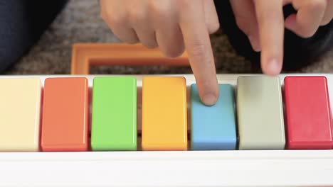 child playing toy piano with colours of the rainbow at home stock video