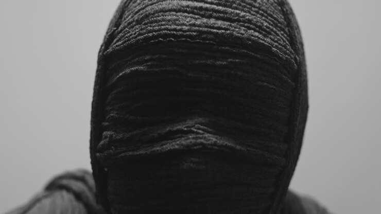 Una mummia di donna su uno sfondo bianco guarda in camera