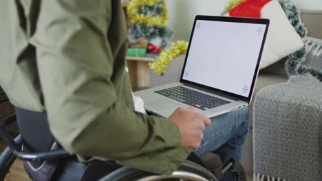 Hombre-Discapacitado-Caucásico-Sentado-En-Silla-De-Ruedas-Usando-Una-Computadora-Portátil-En-Navidad