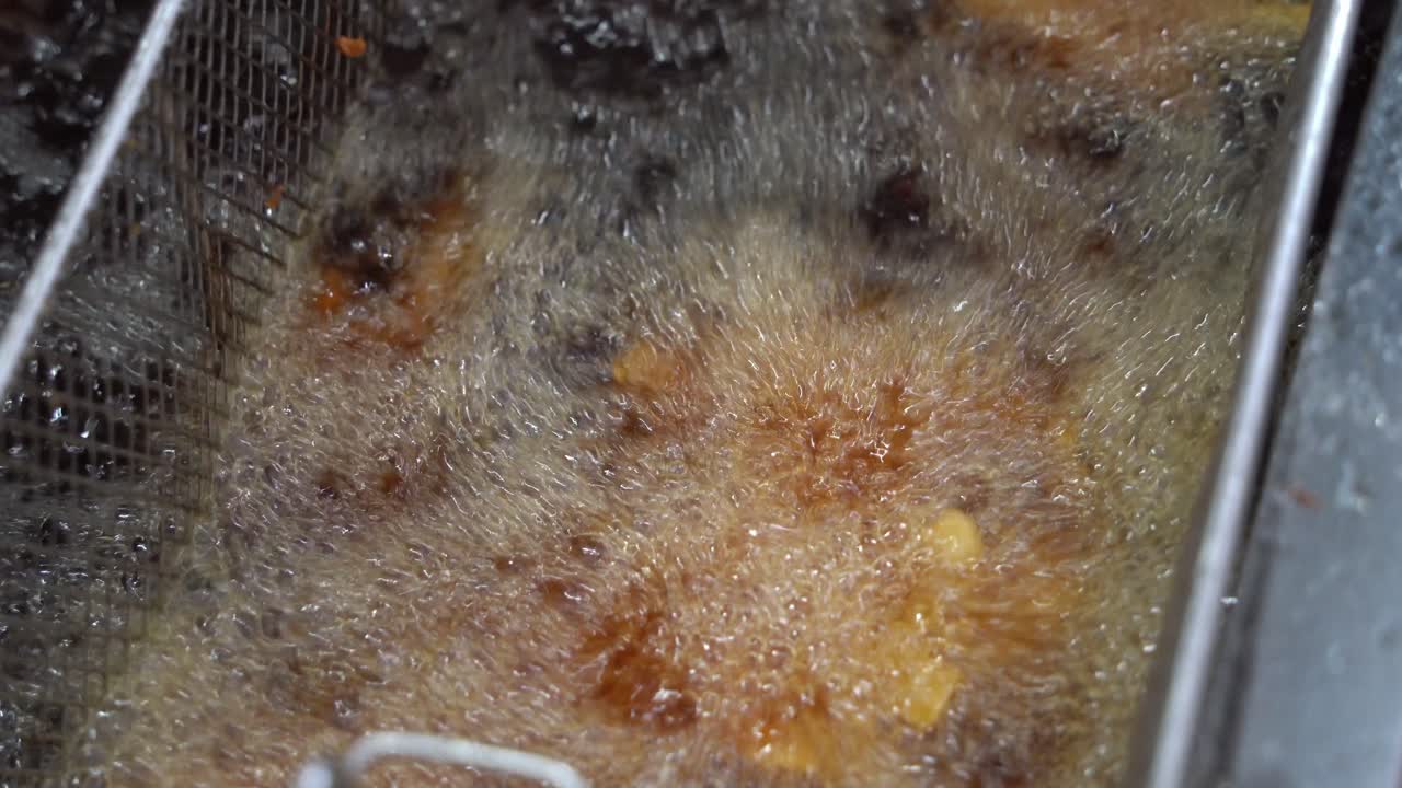 황금 맥주 배터 스테이크 두껍게 자른 감자 칩 튀김, 끓는 뜨거운 기름에 가라 앉고 패스트 푸드 상업용 주방 설정, 클로즈업 샷