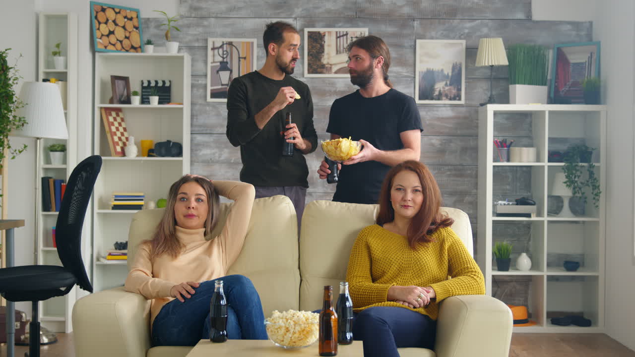 Gruppo di amici che guarda una partita di calcio in salotto