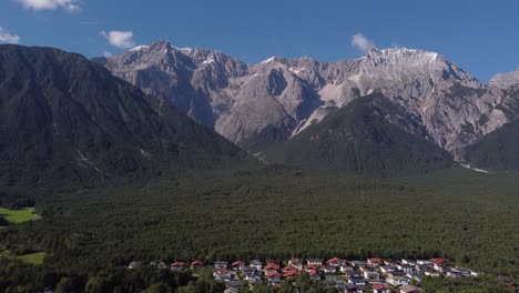 Drone-Volando-A-La-Izquierda-Horizontalmente-Con-Una-Enorme-Montaña-De-Los-Alpes-Y-Bosque-A-La-Vista-En-Austria