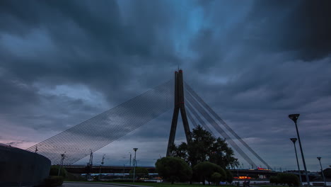 silueta del puente colgante sobre el río daugava en riga con nubes de tormenta arriba