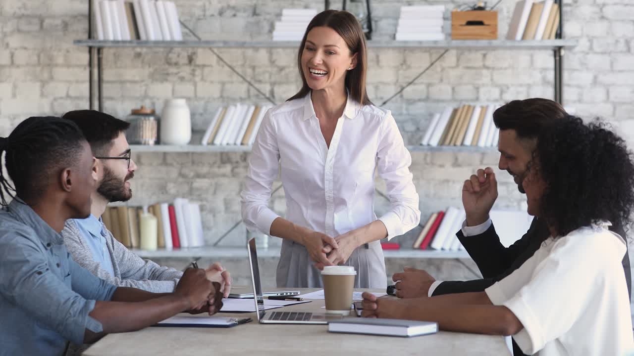jefa orgullosa motiva al equipo multirracial en la mesa de reuniones corporativas