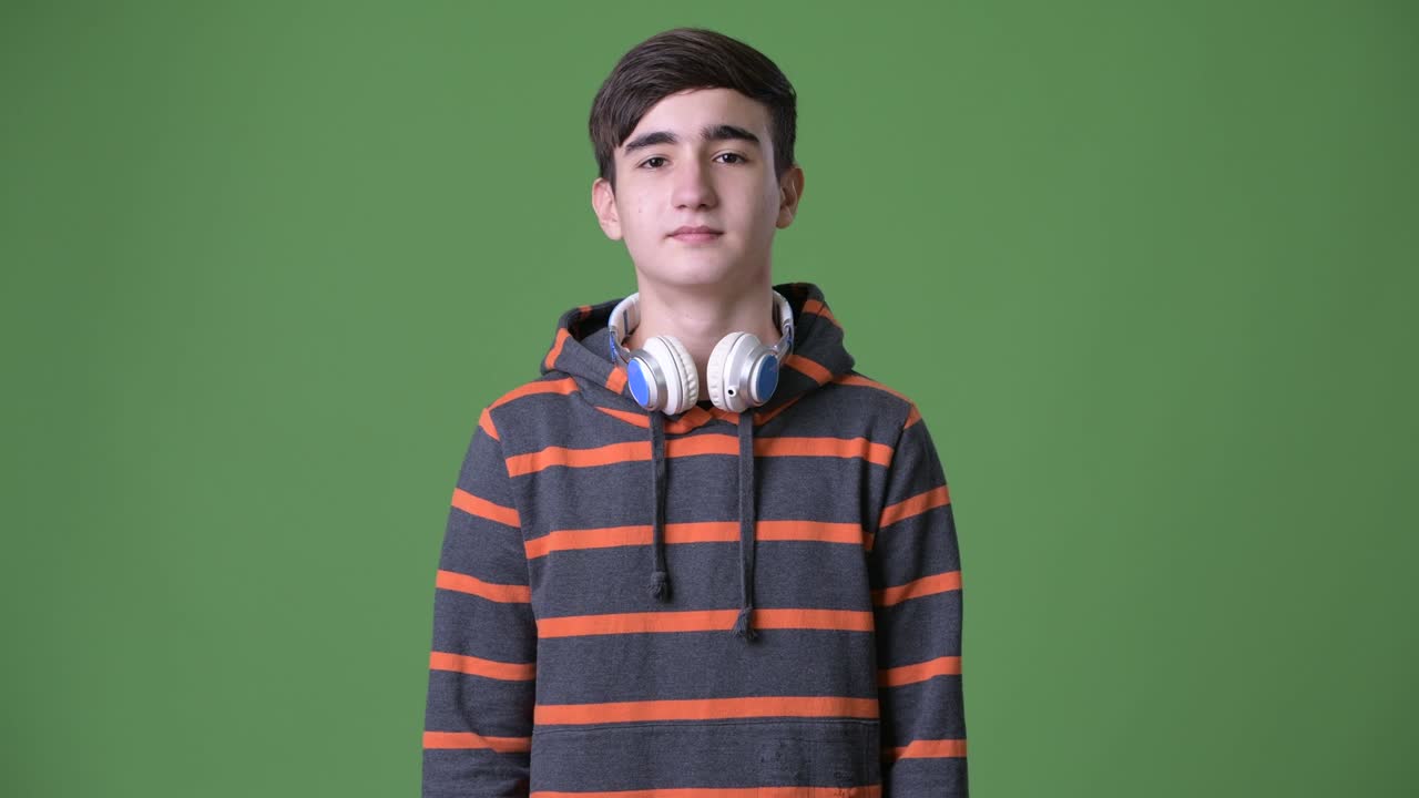 초록색 배경에 젊은 잘생긴 이란 십대 소년