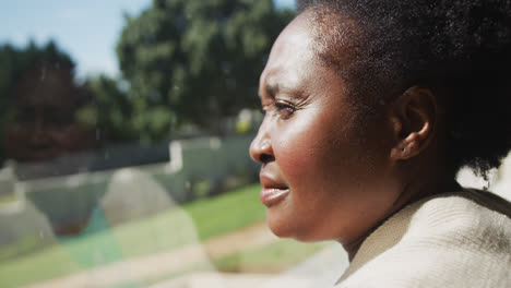 senior african american woman standing by window