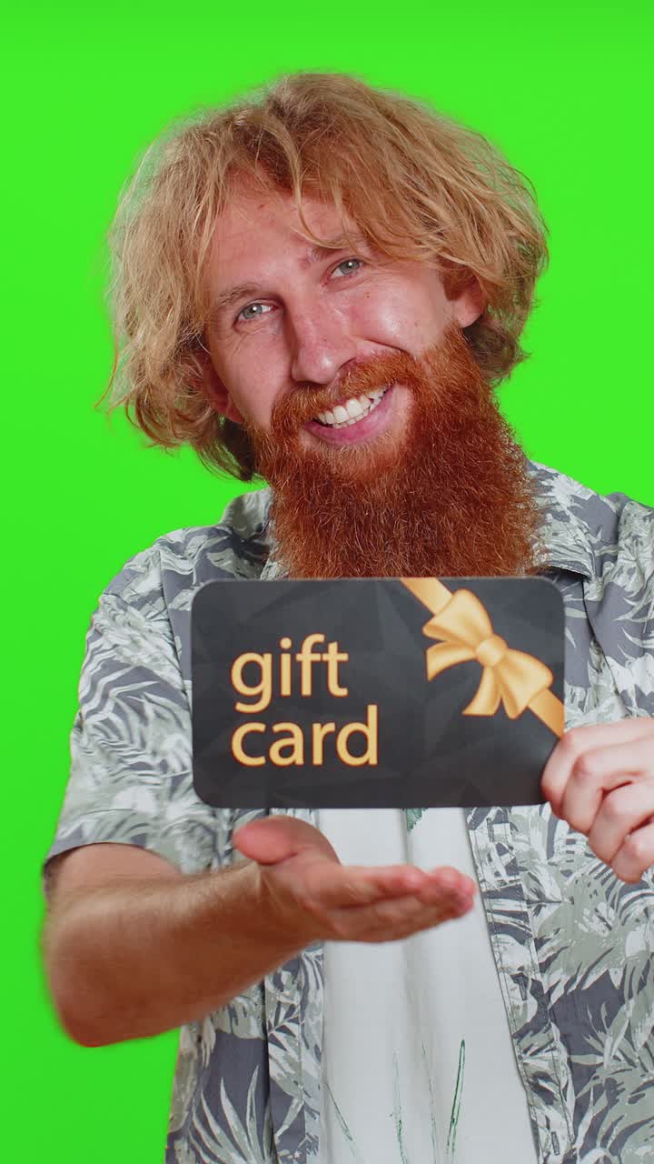 Uomo felice che mostra indicando un buono sconto su un certificato di sconto coupon per la vendita delle vacanze del negozio