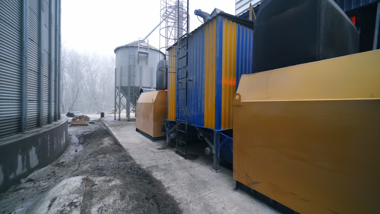 Going around the premises at modern elevator factory. Circle movement around the furnace buildings at granary. Quick motion.
