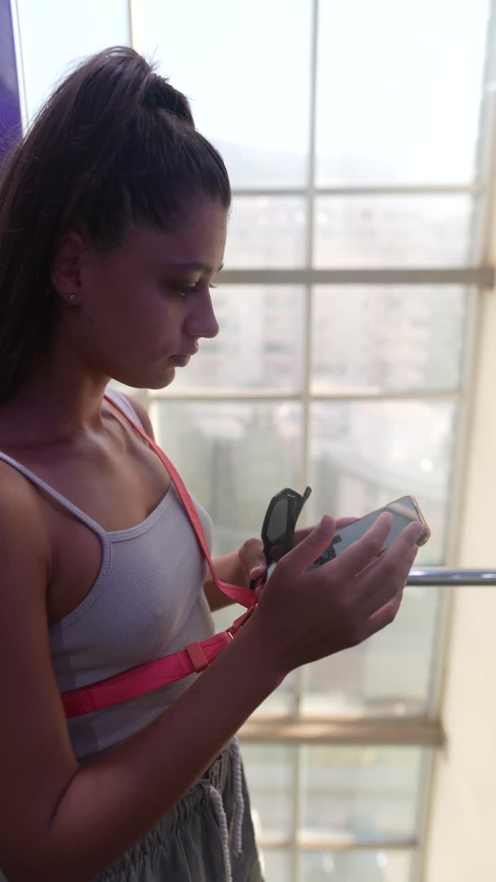 joven usando un teléfono inteligente en el ascensor