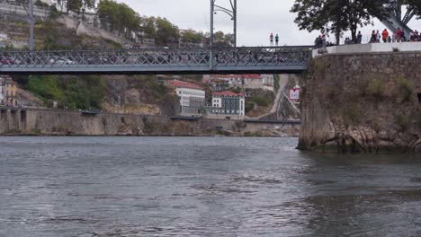 Peatones-Cruzando-El-Pintoresco-Puente-Del-Río-Dom-Luis-I-En-Porto,-Portugal