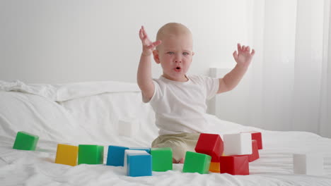 baby playing with blocks on a bed