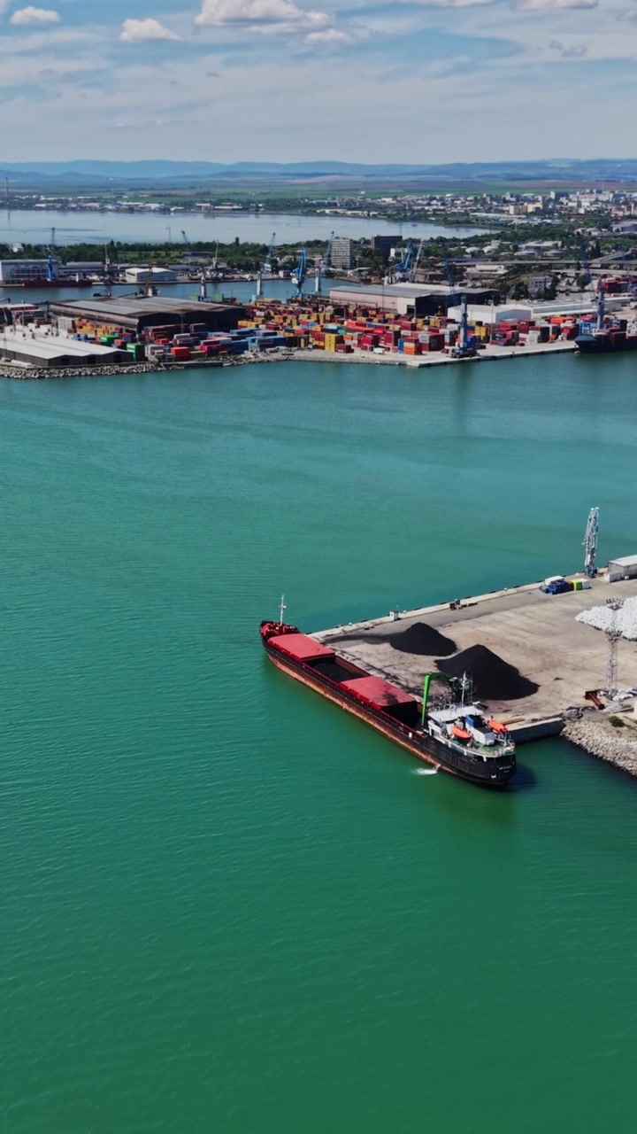 Attività portuale in una giornata soleggiata con navi in acqua e città in lontananza
