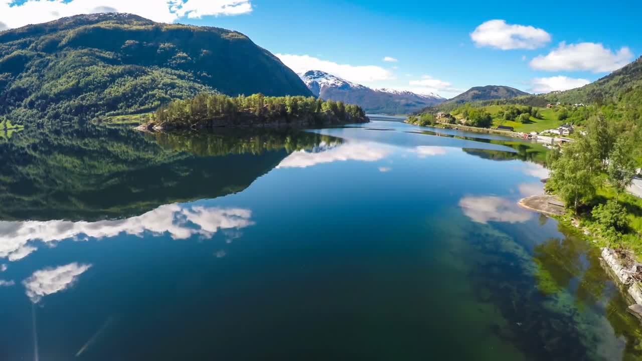 Scenic mountain road and lake reflections in sunny weather
