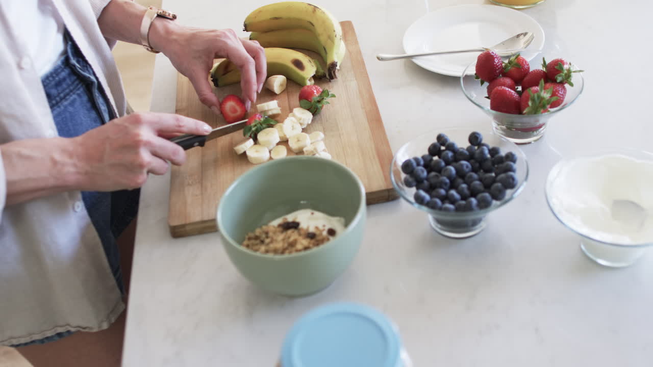 중년 백인 여성이 집에서 아침 식사를 준비하고, 복사 공간이 있습니다.