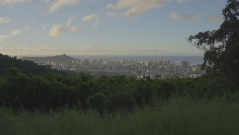 vista de la montaña de la ciudad de honolulu, hawai mientras el sol poniente refleja tonos rosados en las nubes, el agua azul del pacífico adorna el horizonte