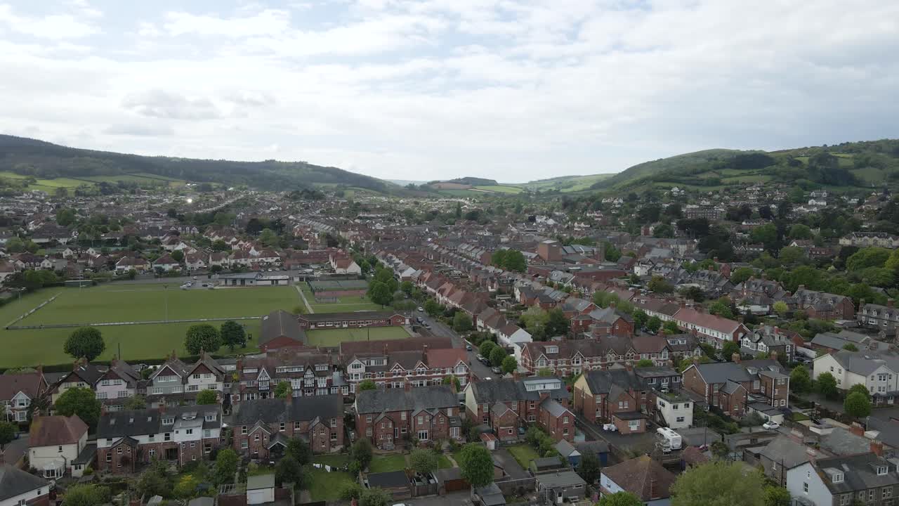 Vista aerea di Minehead, una splendida cittadina costiera storica ai margini di Exmoor, nel Somerset occidentale. Drone che si muove in avanti sopra gli edifici della città in direzione delle colline di Exmoor