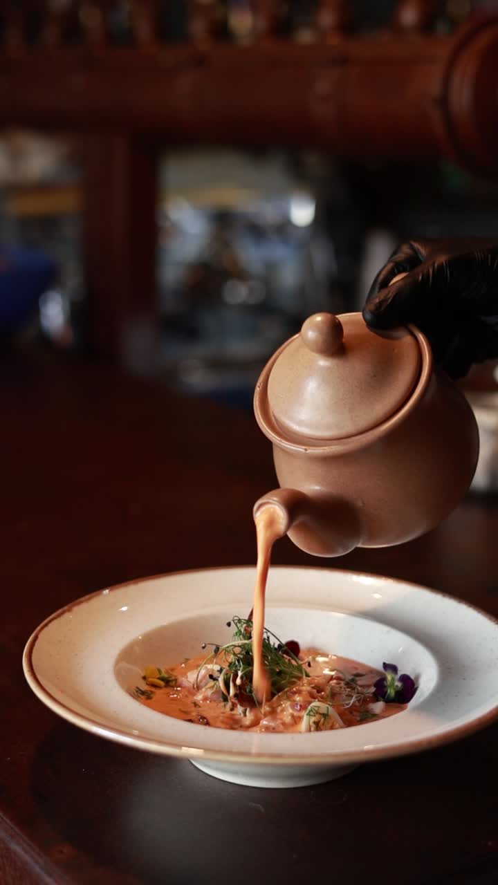 수프 가 접시 에 부어지고 있다