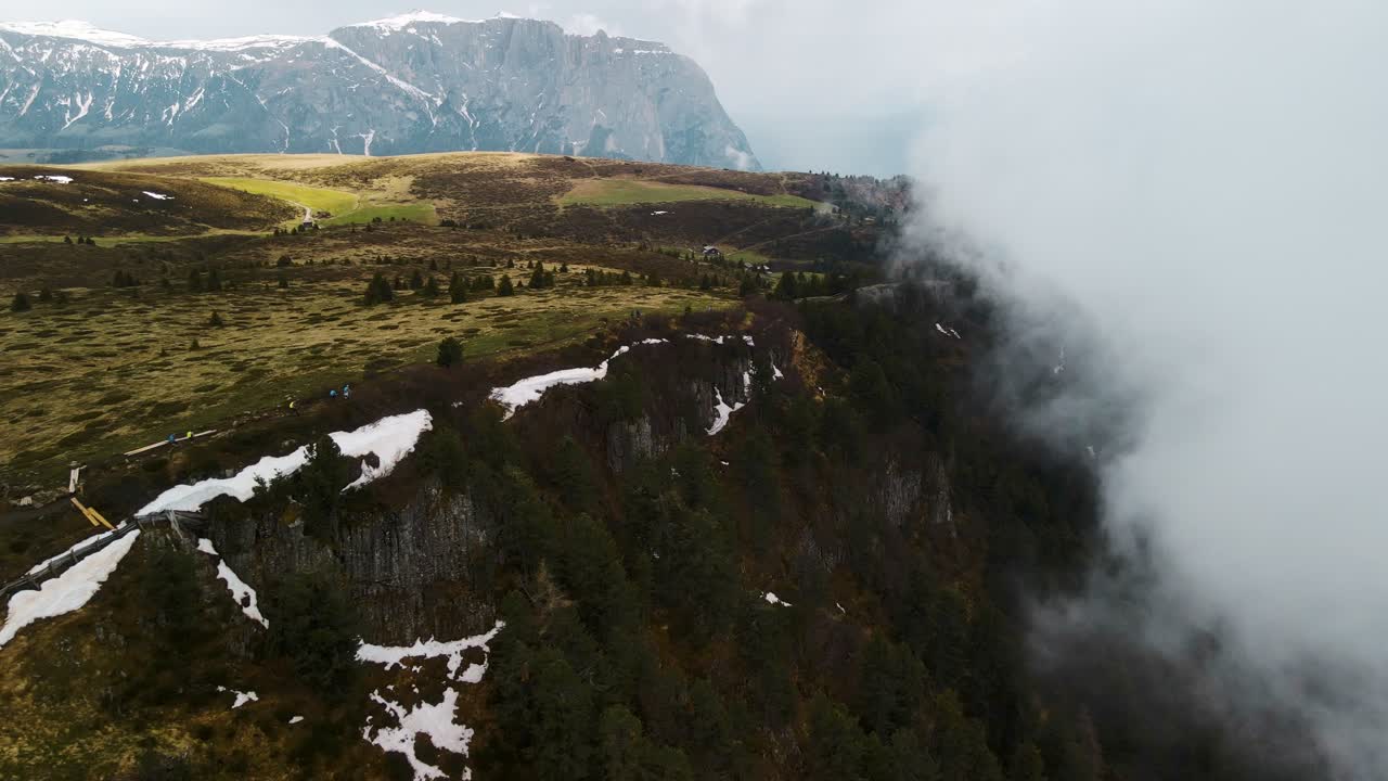 Establishing Shot Revealing Cliff Side-Way covered with Fog, Clouds And Green Vegetation - SEISER ALM MOUNTAIN TOP